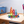 Colorful geometric building blocks on a wooden table with a rainbow in the background
