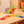 Colorful magnetic building blocks on a wooden surface with a dinosaur toy in the background.